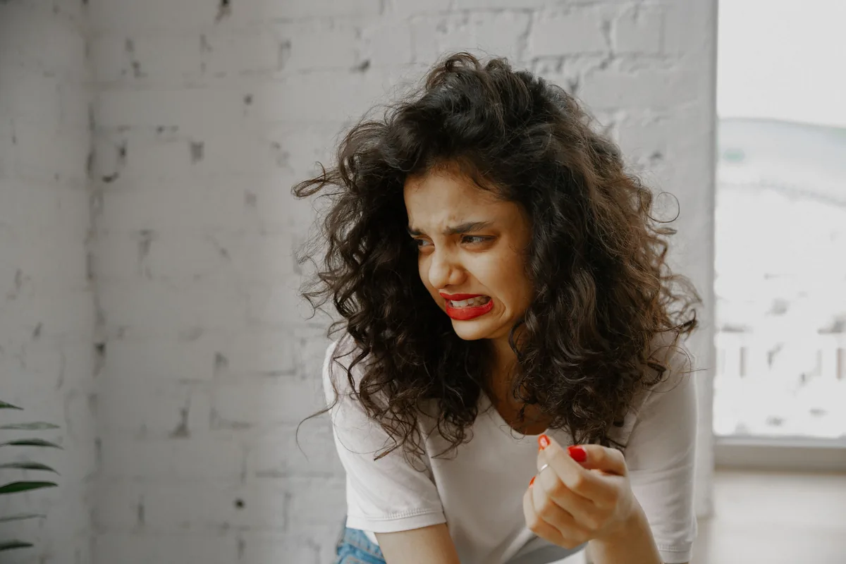 Woman wincing and turning away from a bad smell