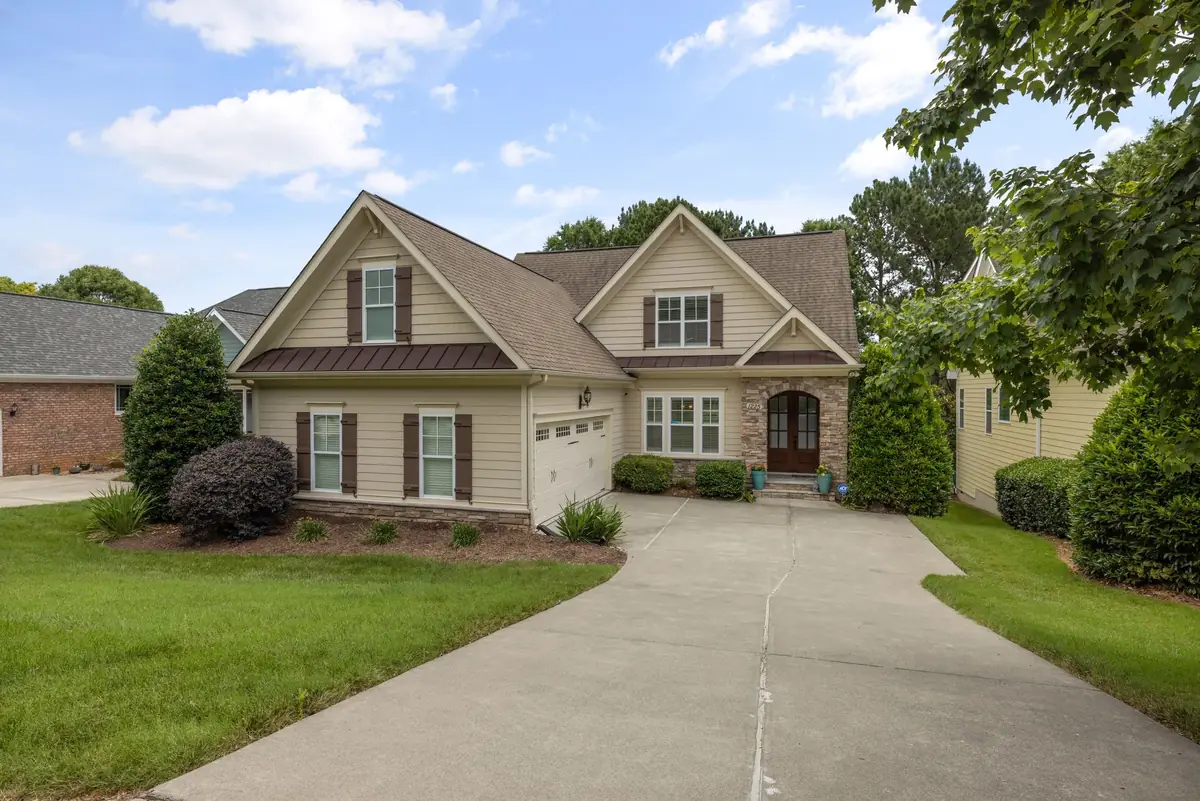 Brick two-story home with a clean driveway and green lawn in a Piedmont Triad neighborhood