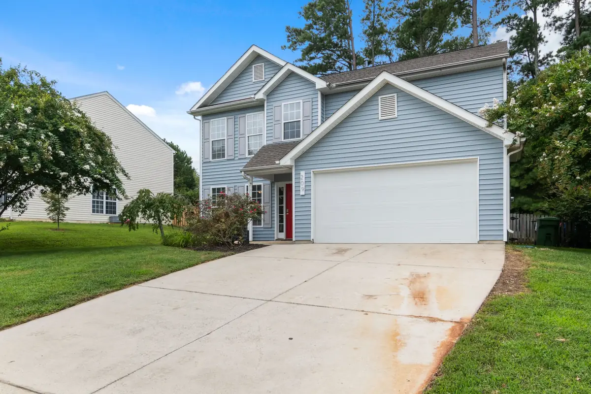 Blue two-story house with a wide, clean concrete driveway